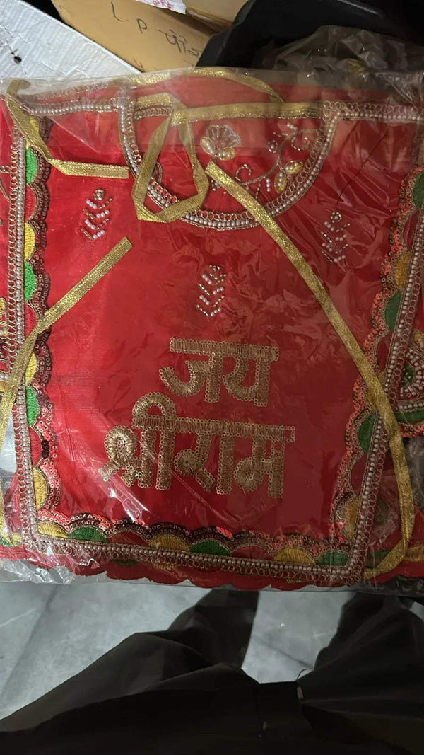 Red pooja chola dress with gold trim, green embroidery, and deity script panel