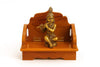 Wooden Bal Gopal singhasan with golden Krishna figurine on front platform