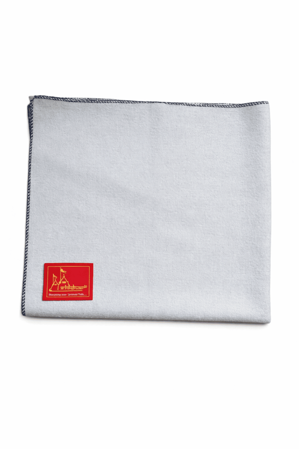 Light blue woolen meditation mat with stitched dark border and red logo patch corner