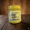 Action Abeer kumkum powder jar on wooden surface, yellow lid and front label