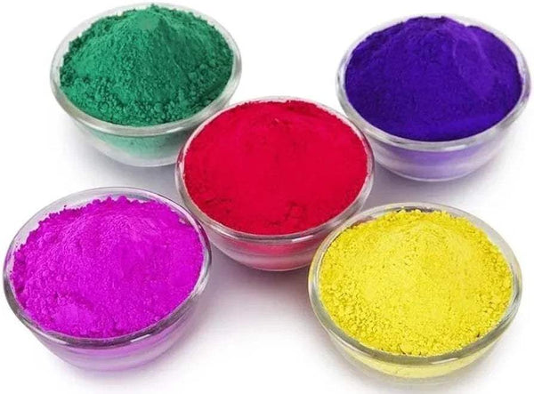 Assorted gulal powder in five small bowls: green, purple, red, pink, and yellow