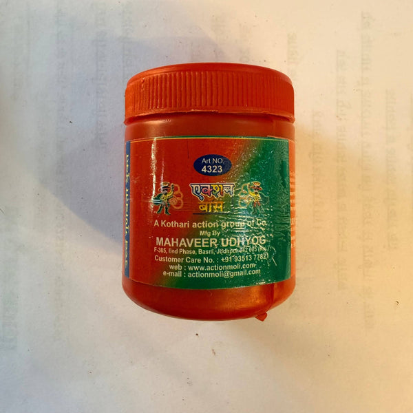 Red kumkum sindur powder jar with ribbed cap, back label and seal visible.