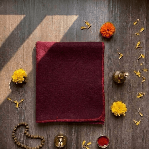Maroon woolen Aasan mat with stitched red border, square folded corners