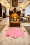 Pink woolen meditation mat laid flat on floor, with red label patch