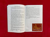 Open book with printed text pages and a decorative emblem on the right page