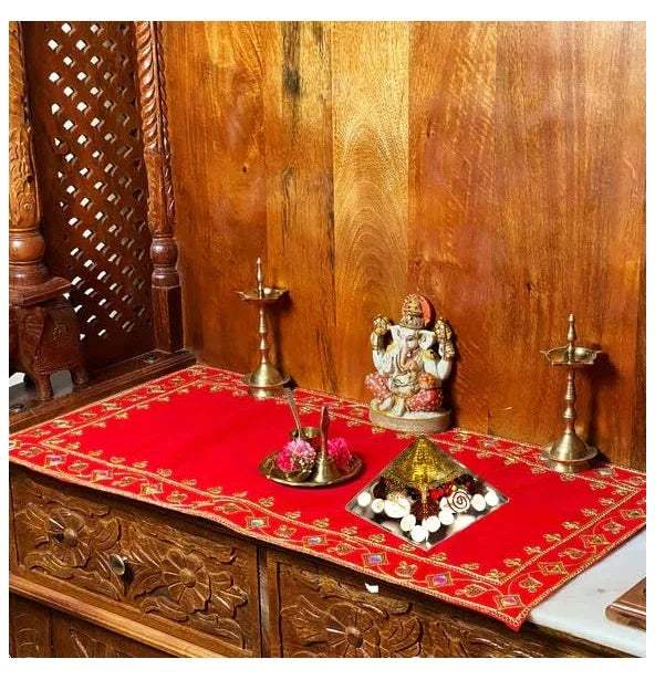 Golden crystal pyramid decoration on red fabric with surrounding white accents
