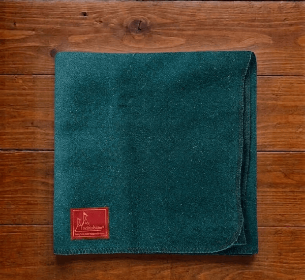 Green woolen pooja asan square mat with red brand tag on teal fabric