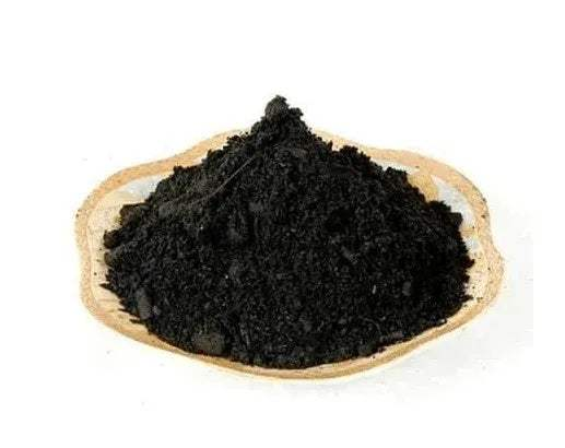 Black incense powder mounded in a shallow wooden bowl