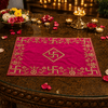 Pink velvet puja cloth with gold embroidered border and central swastika, laid on table