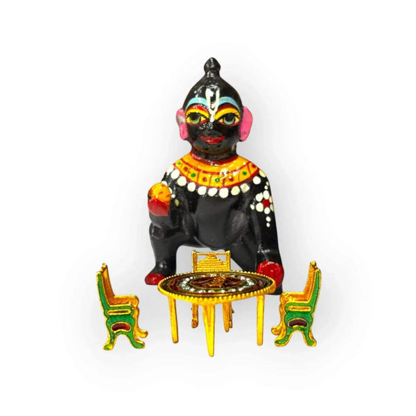 Krishna figurine with toy dining table and four chairs, round red center top
