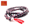 Beaded mala bracelet with dark red and black beads, tied red tassels