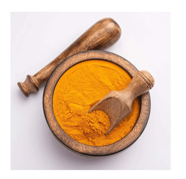 Turmeric powder in a wooden bowl with a wooden spoon