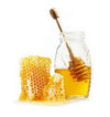 Honey in glass jar with wooden honey dipper and honeycomb
