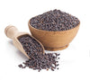 Black mustard seeds in wooden bowl with wooden scoop and scattered seeds