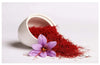 Baby saffron threads from a white cup with a purple saffron flower