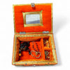 Decorative velvet storage box open with red lining and jeweled accessories inside