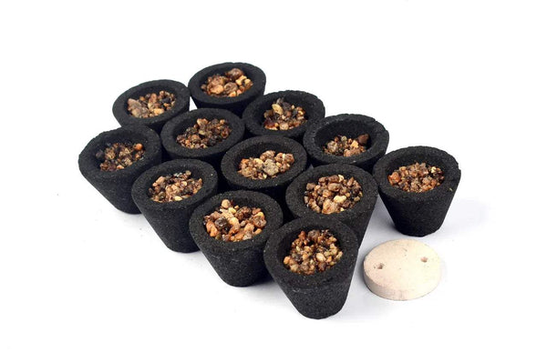 Black incense dhoop cups with resin-filled tops and a small white disc