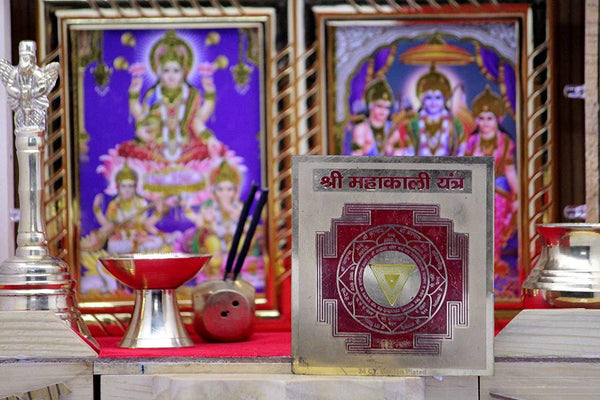 Maha Kali Yantra card displayed upright with maroon circle and gold triangle center