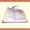 Open diary with printed pages and a pair of eyeglasses resting on top
