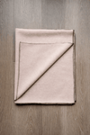 Folding light beige woolen meditation mat with black stitched border