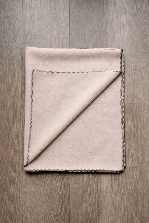 Folding light beige woolen meditation mat with black stitched border
