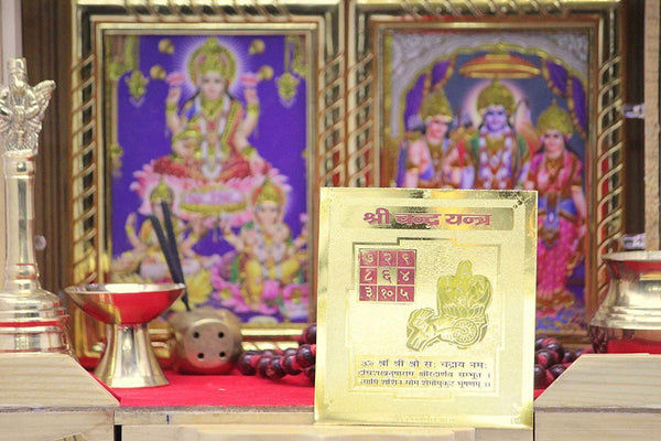 Golden yantra card in open packaging, with lunar chakra grid and seated deity art