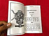 Open religious book with line-drawn figure and Hindi text on cream pages