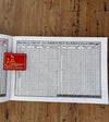Panchang book with open pages showing rows of dates and astrological tables