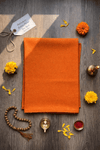 Orange woolen aasan meditation mat folded rectangle, with neat edges and smooth texture.