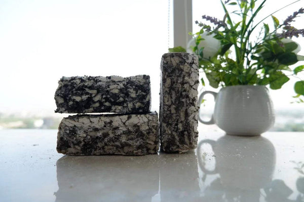 Black loban dhoop resin blocks, stacked on a smooth surface