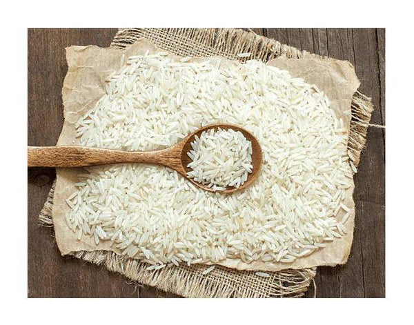 Uncooked white rice in burlap with wooden spoon and small bowl