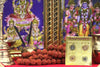 Gold yantra card packet with circular emblems on ceremonial table