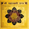 Gold yantra card with central lotus mandala and black Devanagari text border.
