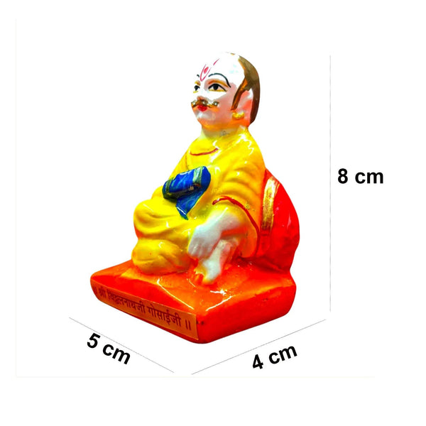 Seated idol front view; 8 cm tall, yellow robe with blue sash on red base