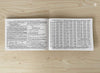 Open panchang booklet spread with dense text blocks and a large printed table