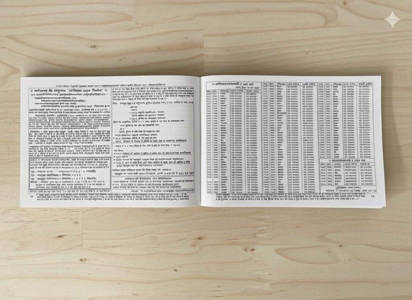 Open panchang booklet spread with dense text blocks and a large printed table