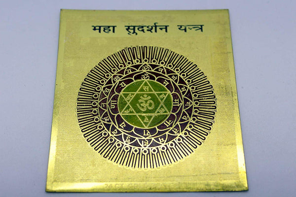 Gold-tone Yantra square card with central green-and-gold circular emblem