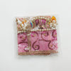 Decorative chunri cloth in pink-purple with gold trim, pearl strands, and embroidered motifs