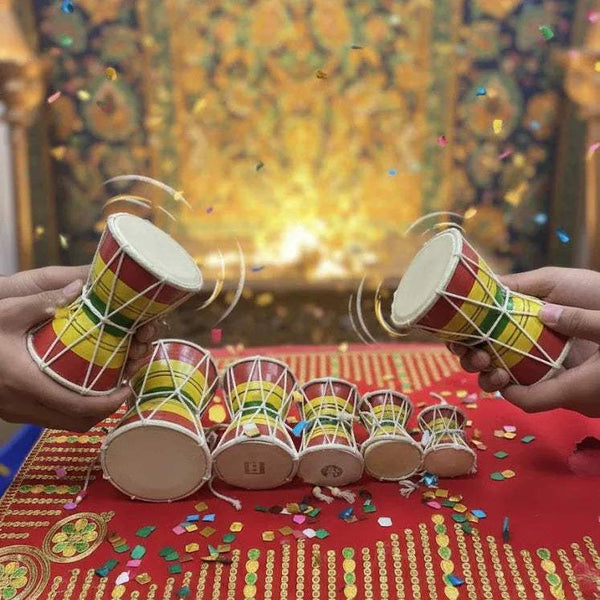 Damru drums held in hands, showing red, yellow, and green striped bodies