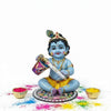 Sitting Krishna figurine on decorated plate with two gold bowls
