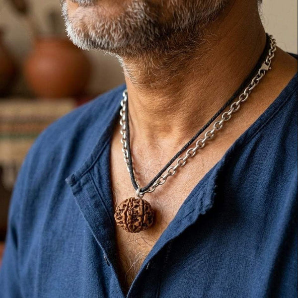 Seven Mukhi Rudraksha pendant on chain at collar, close-up on wearer