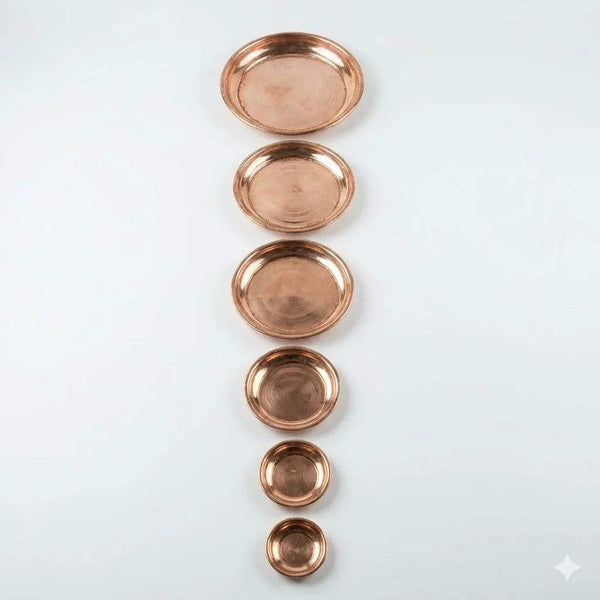 Stack of copper pooja plates (tamra thali) in different sizes, round bowls