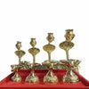 Four gold jelhari pooja water stands on a red display tray