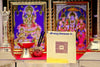 Gold yantra card with black square mandala and Devanagari text on a platform