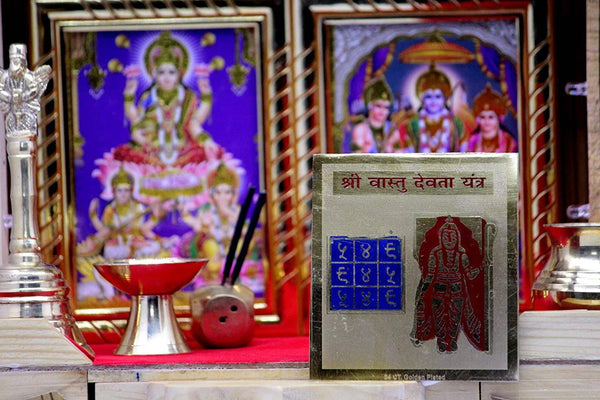 Framed yantra card with maroon deity and blue grid symbols on pale backing