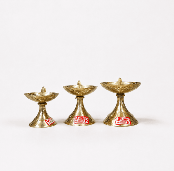 Brass aarti diya stand set, four shallow oil cups on pedestal bases.
