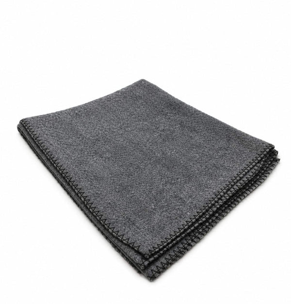 Dark gray wool meditation mat, neatly folded with textured surface and stitched edge