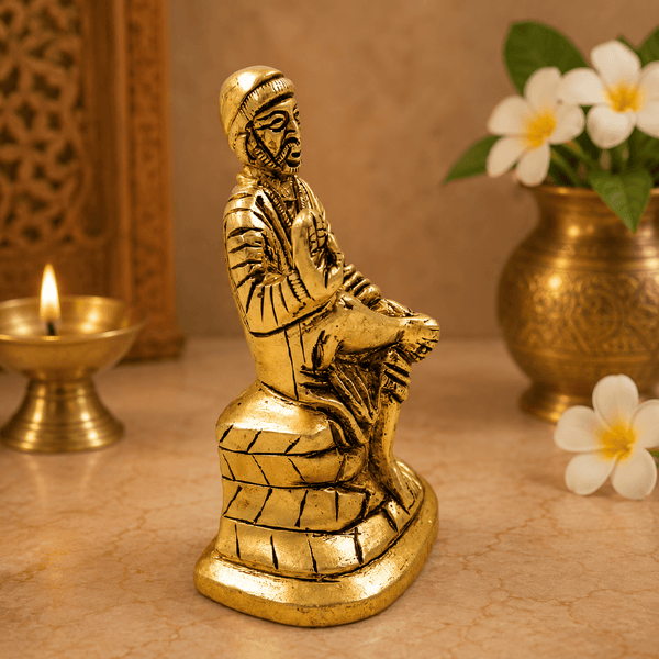 Golden Sai Baba idol statue, seated pose with right hand raised, carved folds