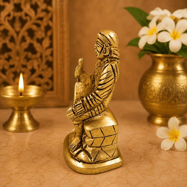 Golden Sai Baba idol statue, seated with hands raised, detailed carved robe