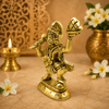 Golden Hanuman idol holding a mountain on a raised hand, side view